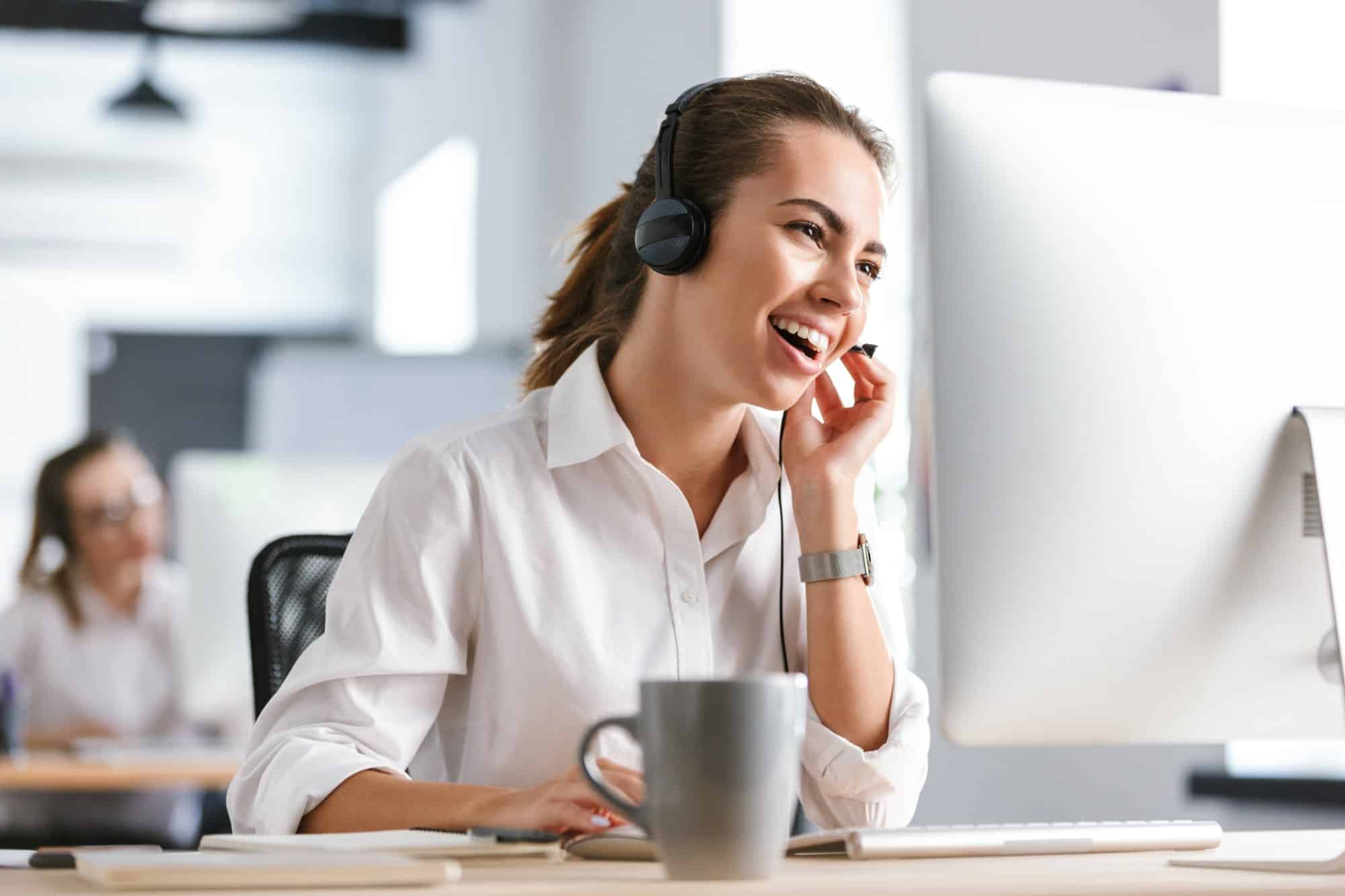 business woman in office callcenter working with computer wearing headphones