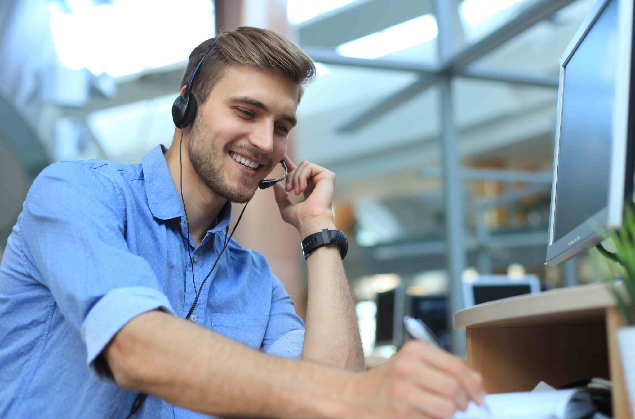 Man writing notes in call center